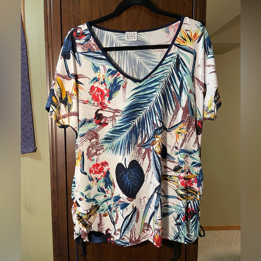 V neck short sleeved shirt in tropical print on a white background.